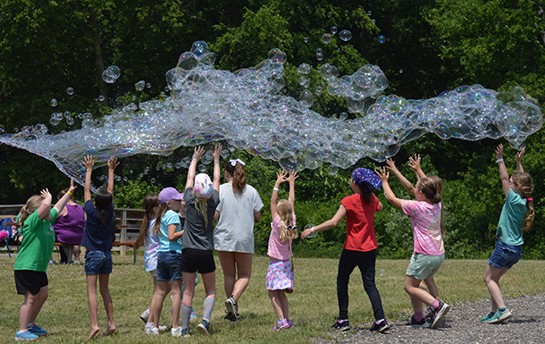 girl scouts chasing bubbles